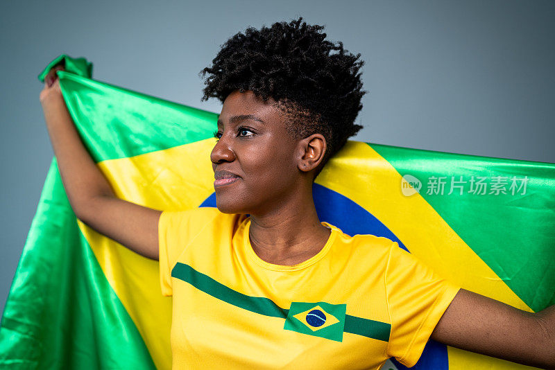 年轻的女运动员/球迷举着巴西国旗